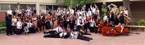 Student orchestra posing for group photo with instruments